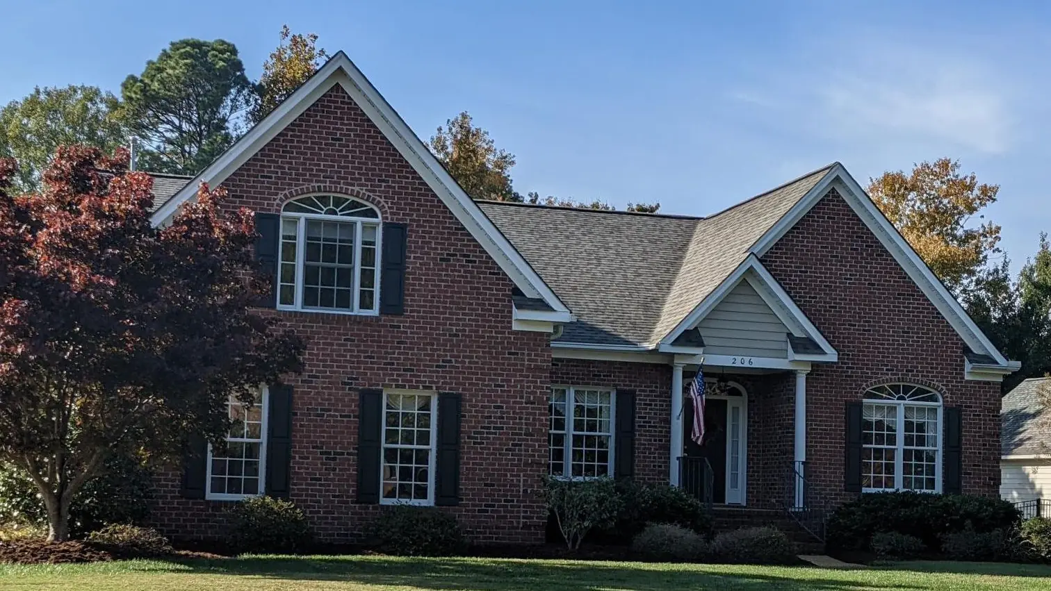 Wide view of the roof of the same brick home, showing ridge lines and gables