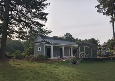 Small grey outbuilding or cottage with a new roof