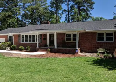 Brick ranch home with a grey shingle roof